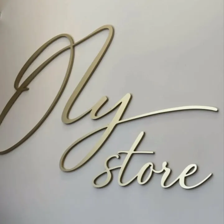 Letreiro dourado Oly store na parede da loja
